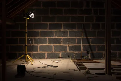 Basement block wall lit by a yellow work light during renovation