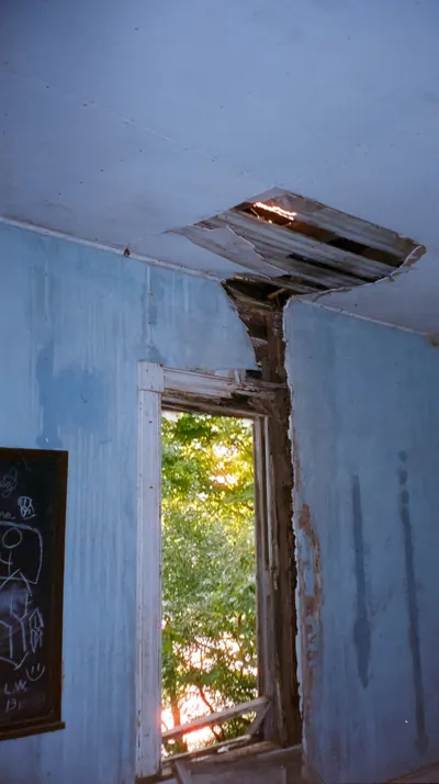 Damaged blue room with a hole in the ceiling from a leak