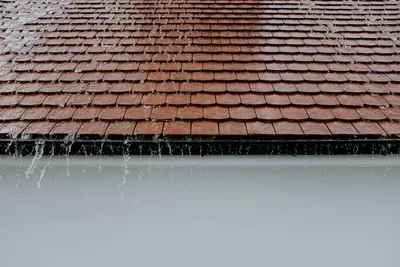 Rain running off a tile roof into a gutter